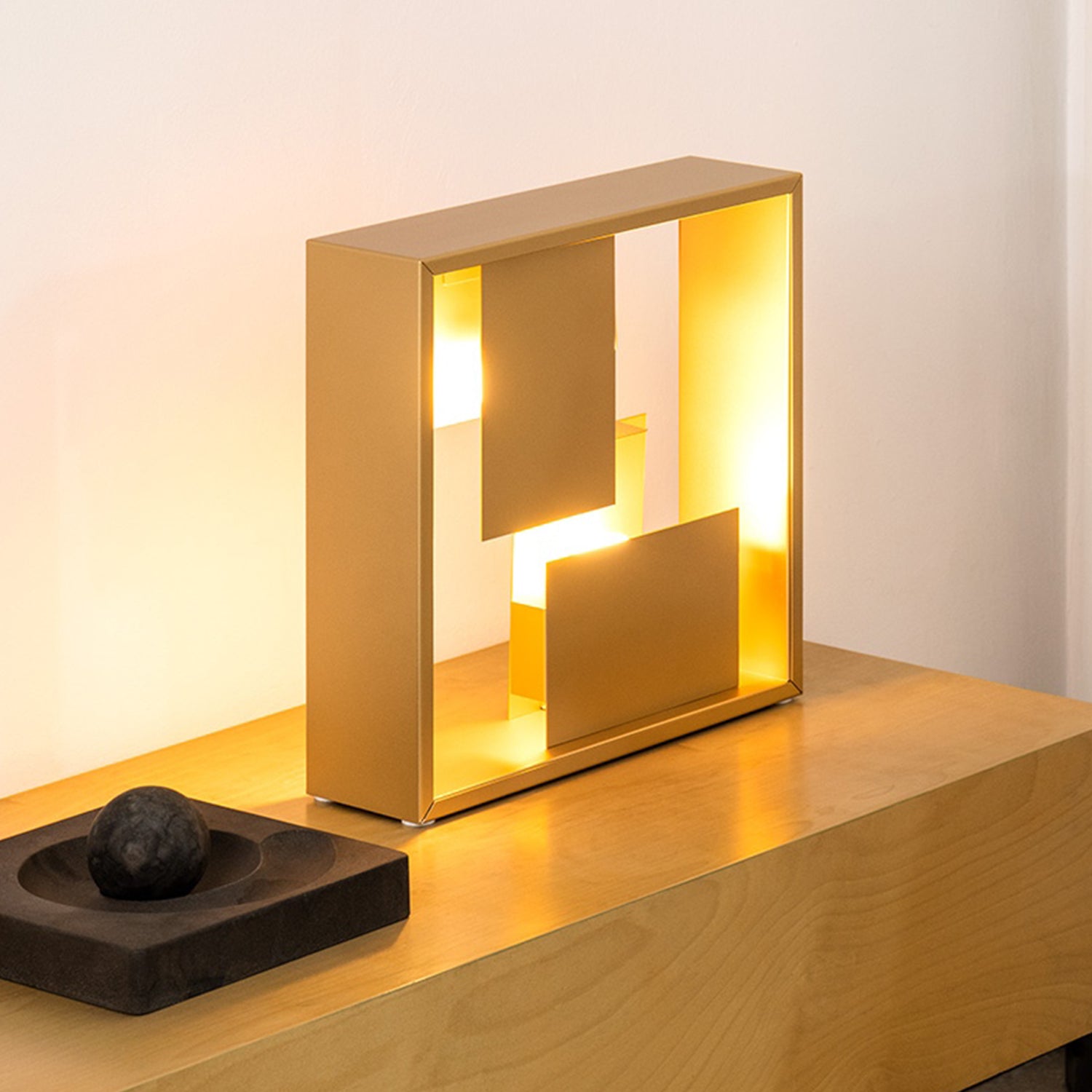 Artemide Fato Table Lamp in gold on a table