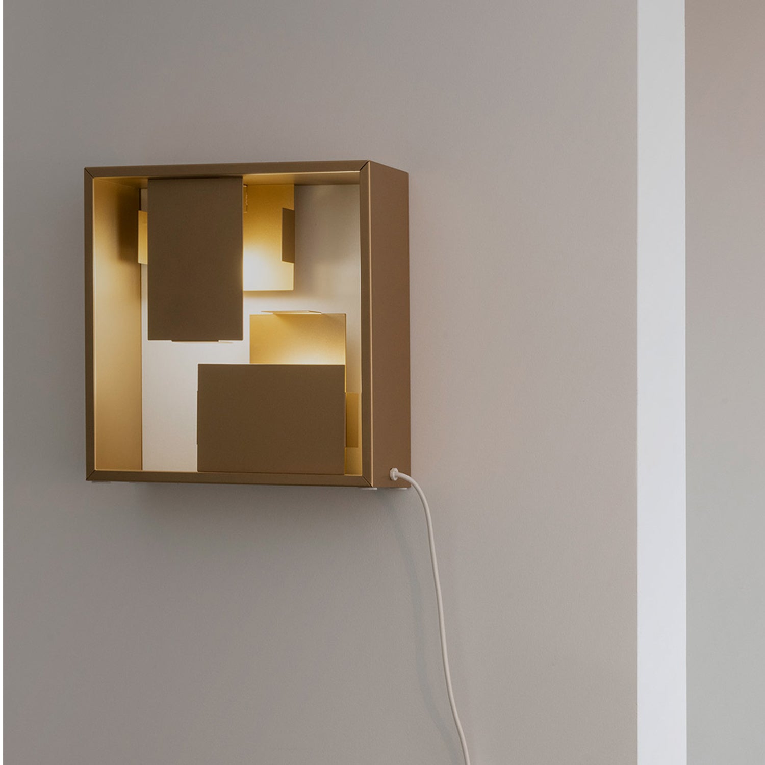 Artemide Fato Table Lamp in gold mounted on a wall